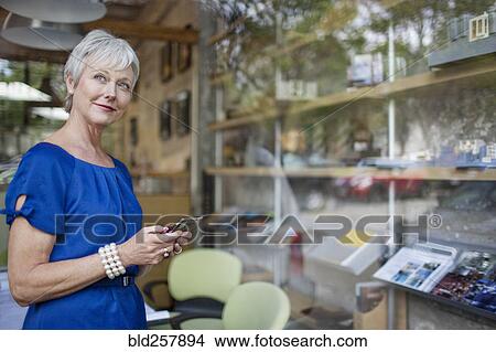 Picture - Pensive Caucasian businesswoman texting on cell phone. Fotosearch