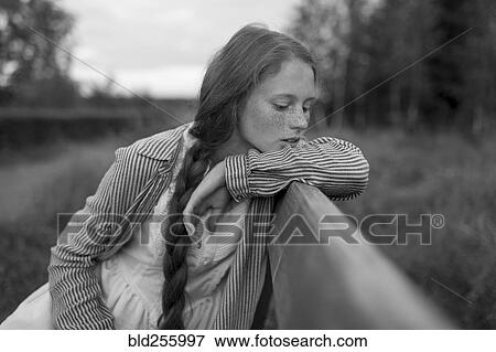Stock Photo - Pensive Caucasian girl sitting on bench. Fotosearch