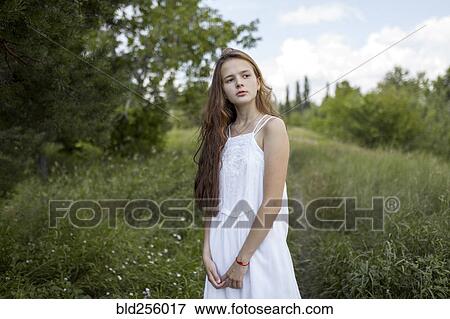 Pensive Caucasian girl standing in field View Large Photo Image Stock Photo - Pensive Caucasian girl standing in field. Fotosearch