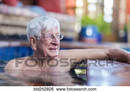 Stock Photograph - Pensive Caucasian man in swimming pool. Fotosearch