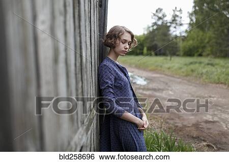 Pensive Caucasian woman leaning on wooden fence View Large Photo Image Stock Photograph - Pensive Caucasian woman leaning on wooden fence. Fotosearch