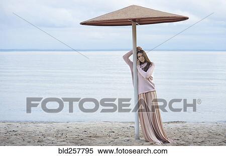 Pensive Caucasian woman leaning on beach umbrella View Large Photo Image Stock Photography - Pensive Caucasian woman leaning on beach umbrella. Fotosearch