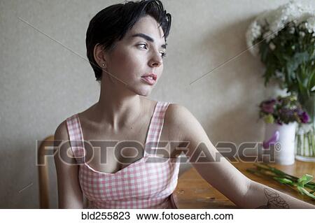 Pensive Caucasian woman sitting at table View Large Photo Image Stock Image - Pensive Caucasian woman sitting at table. Fotosearch