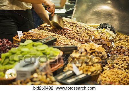 Person scooping nuts at market View Large Photo Image Stock Image - Person scooping nuts at market. Fotosearch