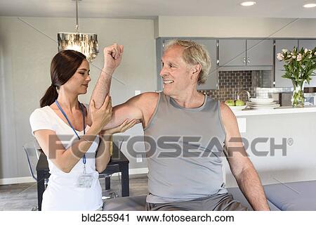 Physical therapist lifting arm of man View Large Photo Image Stock Image - Physical therapist lifting arm of man. Fotosearch