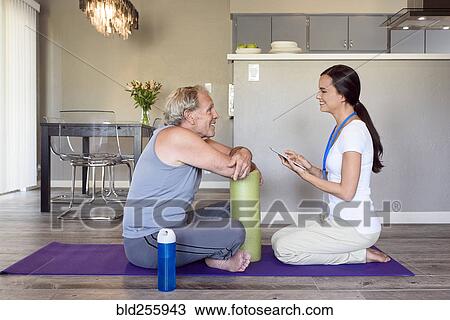 Physical therapist with digital tablet talking to man View Large Photo Image Stock Image - Physical therapist with digital tablet talking to man. Fotosearch