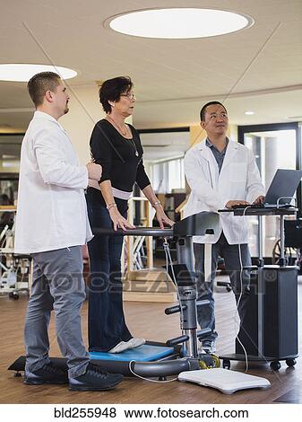 Physical therapists examining patient View Large Photo Image Stock Photo - Physical therapists examining patient. Fotosearch