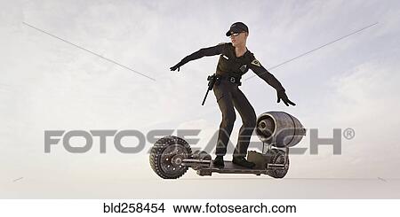 Picture - Police officer riding futuristic skateboard. Fotosearch