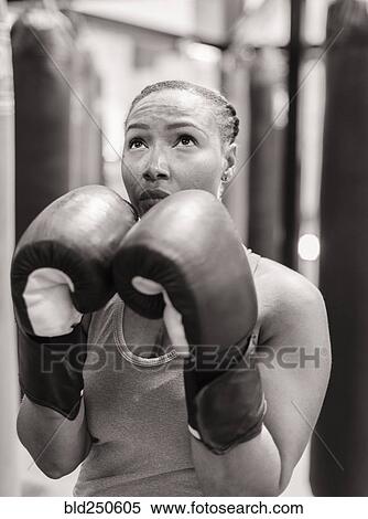 Portrait of Black woman wearing boxing gloves looking up View Large Photo Image Stock Photography - Portrait of Black woman wearing boxing gloves looking up. Fotosearch