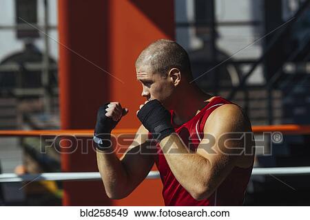 Stock Photo - Portrait of Caucasian boxer with fists raised. Fotosearch