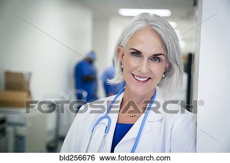 Portrait of Caucasian doctor leaning on wall in hospital View Large Photo Image Stock Photograph - Portrait of Caucasian doctor leaning on wall in hospital. Fotosearch