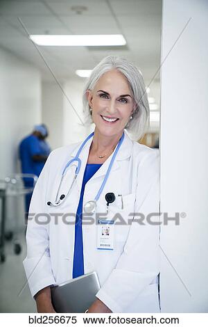 Portrait of Caucasian doctor leaning on wall in hospital View Large Photo Image Stock Photography - Portrait of Caucasian doctor leaning on wall in hospital. Fotosearch
