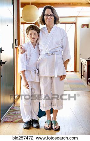 Stock Image - Portrait of Caucasian mother and son wearing martial arts clothing. Fotosearch