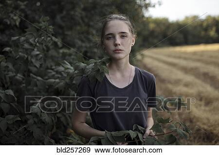 Stock Photo - Portrait of Caucasian teenage girl holding branch. Fotosearch