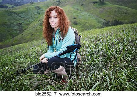 Stock Photo - Portrait of Caucasian woman crouching holding walking sticks. Fotosearch