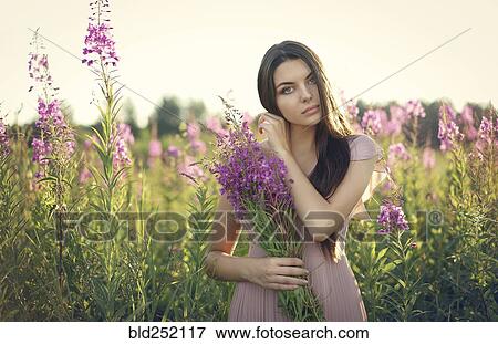 Portrait of Caucasian woman gathering wildflowers in field View Large Photo Image Stock Photo - Portrait of Caucasian woman gathering wildflowers in field. Fotosearch