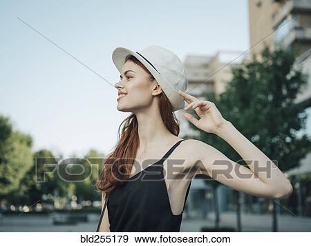 Stock Photo - Portrait of Caucasian woman holding hat. Fotosearch