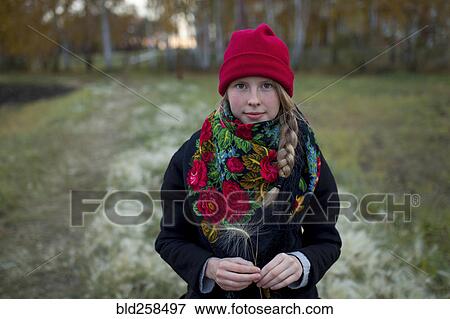 Portrait of Caucasian woman wearing scarf and stocking-cap holding hay seed View Large Photo Image Stock Photo - Portrait of Caucasian woman wearing scarf and stocking-cap holding hay seed. Fotosearch