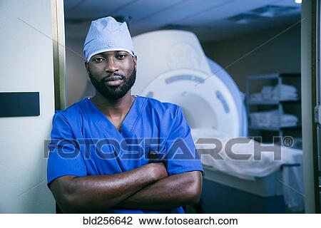Stock Image - Portrait of confident black nurse near scanner. Fotosearch