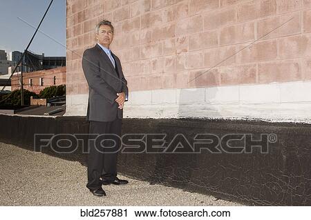 Portrait of confident Hispanic businessman standing near brick wall View Large Photo Image Stock Image - Portrait of confident Hispanic businessman standing near brick wall. Fotosearch