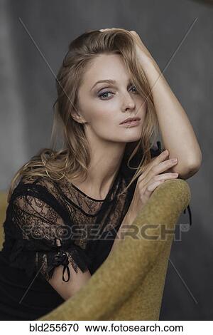 Portrait of glamorous Caucasian woman sitting on sofa View Large Photo Image Stock Image - Portrait of glamorous Caucasian woman sitting on sofa. Fotosearch