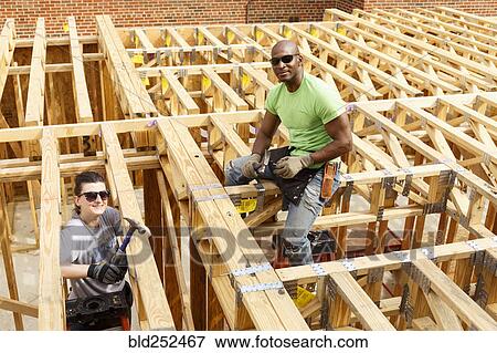 Portrait of man and woman holding hammers at construction site View Large Photo Image Stock Photo - Portrait of man and woman holding hammers at construction site. Fotosearch