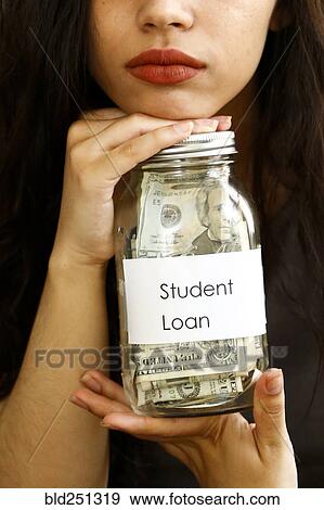 Stock Photograph - Portrait of mixed race woman holding jar of money for student loan. Fotosearch - Search Stock Photography, Posters, Pictures, and Photo Clipart Images