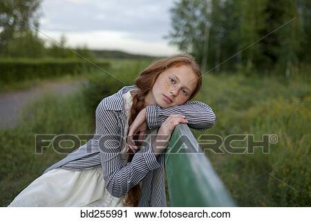Stock Image - Portrait of pensive Caucasian girl sitting on bench. Fotosearch