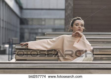 Portrait of pensive Caucasian woman sitting on urban bench View Large Photo Image Picture - Portrait of pensive Caucasian woman sitting on urban bench. Fotosearch