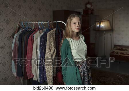 Portrait of pensive Caucasian woman leaning on clothing rack View Large Photo Image Stock Image - Portrait of pensive Caucasian woman leaning on clothing rack. Fotosearch