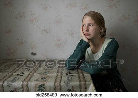 Stock Photo - Portrait of pensive Caucasian woman leaning on table. Fotosearch
