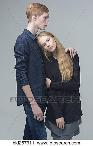 Stock Image - Portrait of serious Caucasian couple hugging. Fotosearch