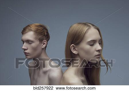 Stock Image - Portrait of serious Caucasian couple with eyes closed. Fotosearch