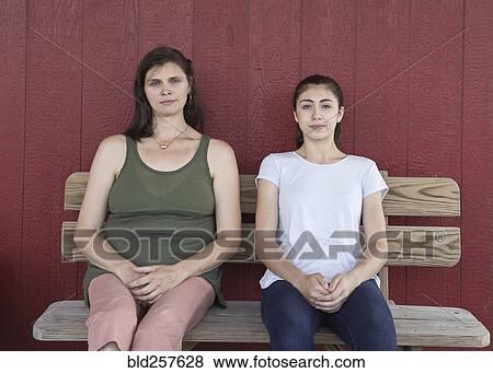 Portrait of serious Caucasian girl and mother on bench View Large Photo Image Stock Photo - Portrait of serious Caucasian girl and mother on bench. Fotosearch