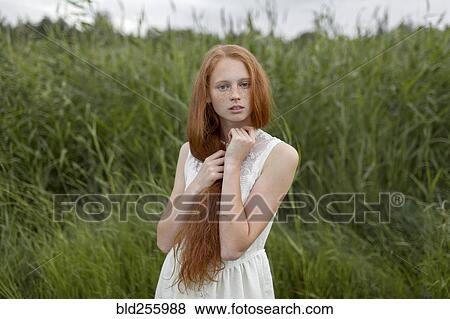 Portrait of serious Caucasian girl with freckles standing in field View Large Photo Image Stock Photo - Portrait of serious Caucasian girl with freckles standing in field. Fotosearch