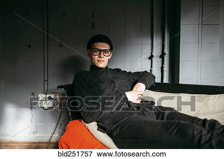 Stock Photo - Portrait of serious Caucasian man on sofa. Fotosearch