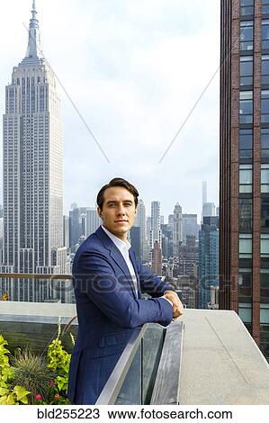 Portrait of serious Caucasian businessman leaning on urban rooftop View Large Photo Image Stock Image - Portrait of serious Caucasian businessman leaning on urban rooftop. Fotosearch