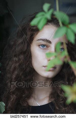 Portrait of serious Caucasian woman behind leaves View Large Photo Image Stock Image - Portrait of serious Caucasian woman behind leaves. Fotosearch
