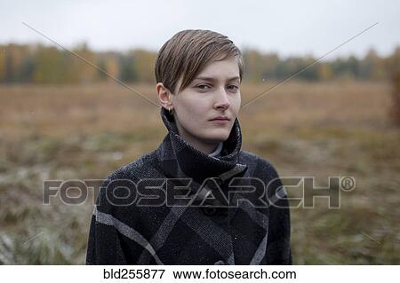 Portrait of serious Caucasian woman standing in field View Large Photo Image Stock Photo - Portrait of serious Caucasian woman standing in field. Fotosearch