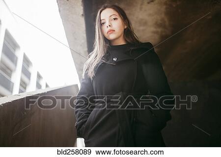 Stock Photo - Portrait of serious Caucasian woman wearing black coat. Fotosearch