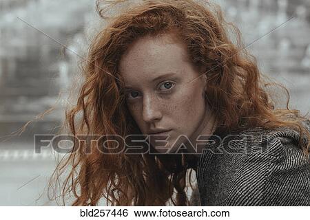 Stock Photograph - Portrait of serious Caucasian woman with red hair. Fotosearch