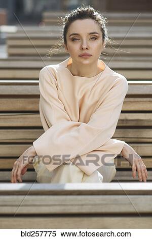 Portrait of serious Caucasian woman sitting on wooden bench View Large Photo Image Stock Photography - Portrait of serious Caucasian woman sitting on wooden bench. Fotosearch