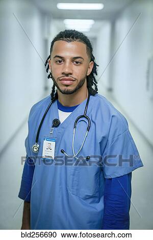 Stock Image - Portrait of serious mixed race nurse. Fotosearch