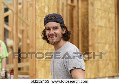 Stock Image - Portrait of smile Caucasian man at construction site. Fotosearch