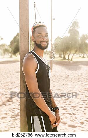 Portrait of smiling black man leaning on beach volleyball net View Large Photo Image Stock Photograph - Portrait of smiling black man leaning on beach volleyball net. Fotosearch