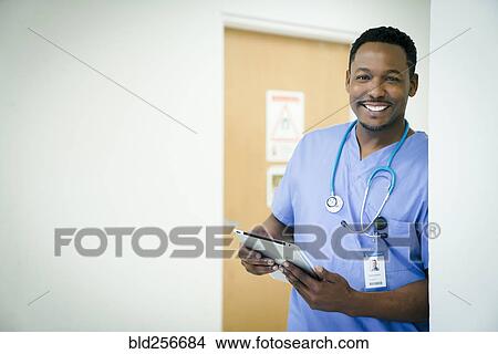 Picture - Portrait of smiling black nurse holding digital tablet. Fotosearch
