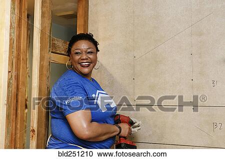 Portrait of smiling black woman holding drill View Large Photo Image Stock Image - Portrait of smiling black woman holding drill. Fotosearch