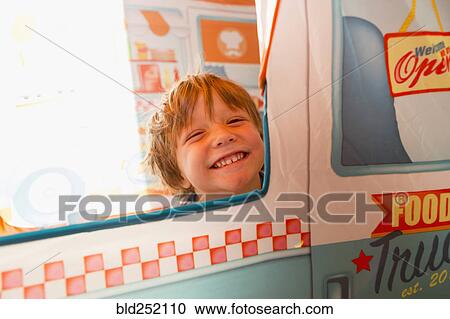Stock Image - Portrait of smiling Caucasian boy in window. Fotosearch