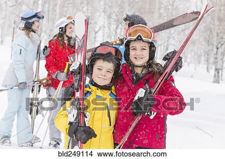 Picture - Portrait of smiling Caucasian brother and sister carrying skis. Fotosearch