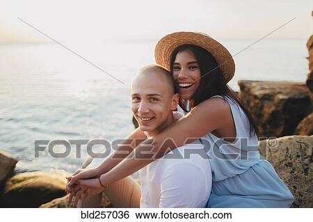 Stock Photograph - Portrait of smiling Caucasian couple at ocean. Fotosearch